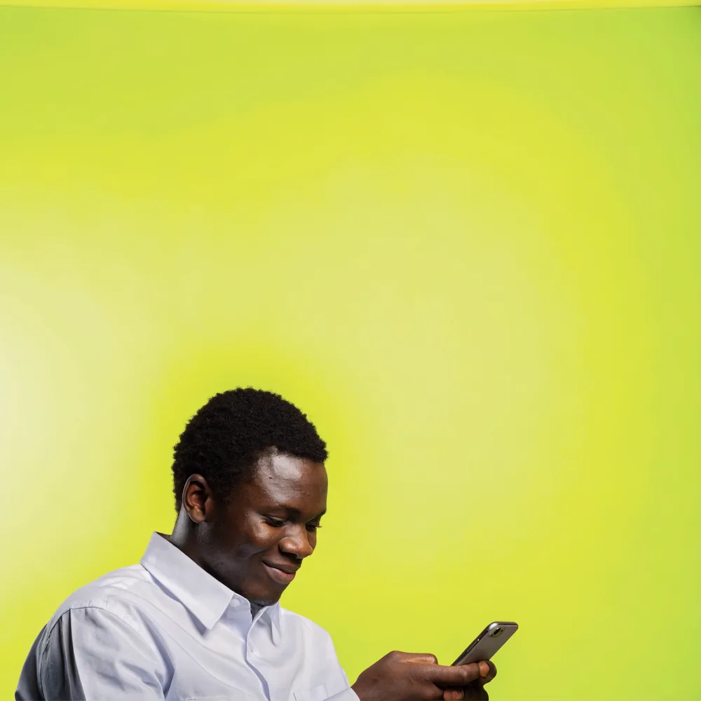 A man looking at his phone against a volt background