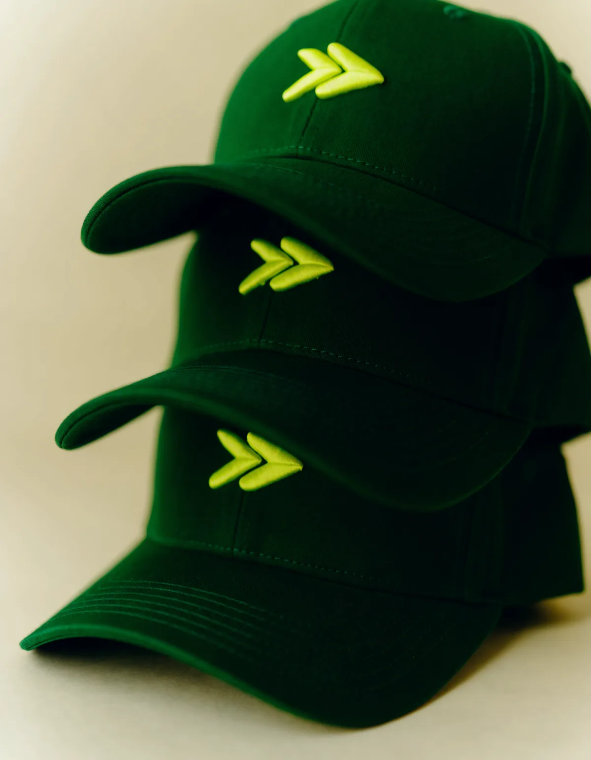 A stack of deep green caps carrying the volt chevron mark