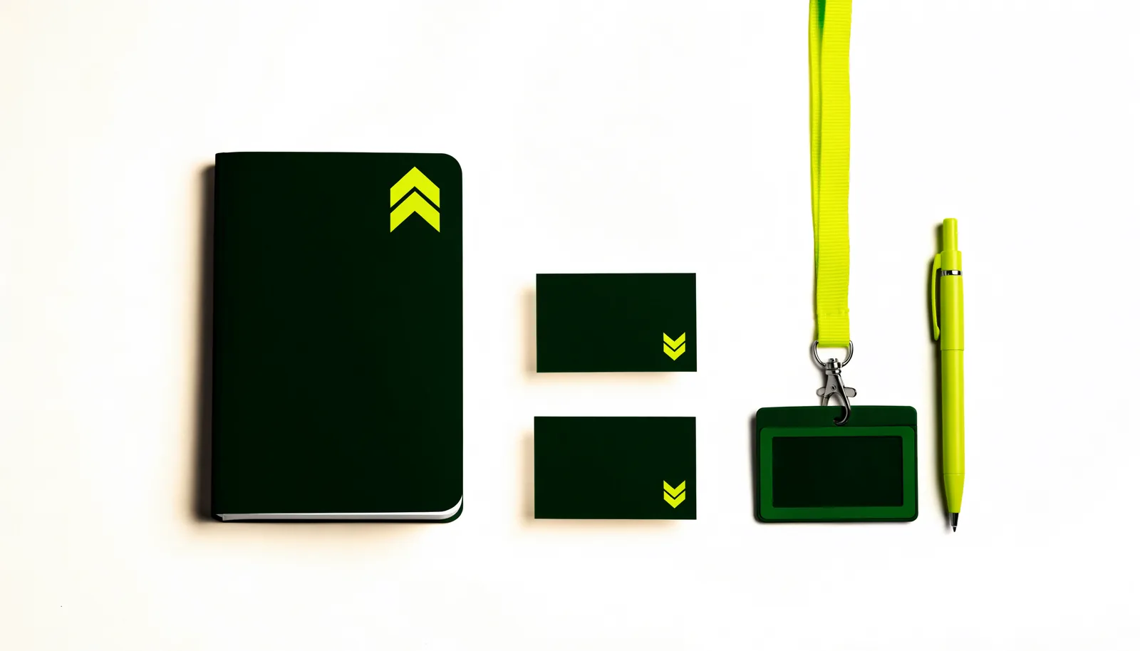 A notebook, cards, lanyard and pen in deep green and volt
